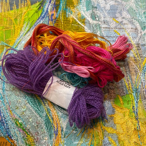 colourful fabric and fabric scraps with bundles of threads on top