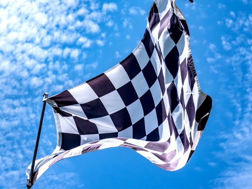 a black and white checkered flag flying in the sky a black and white checkered flag flying in the sky