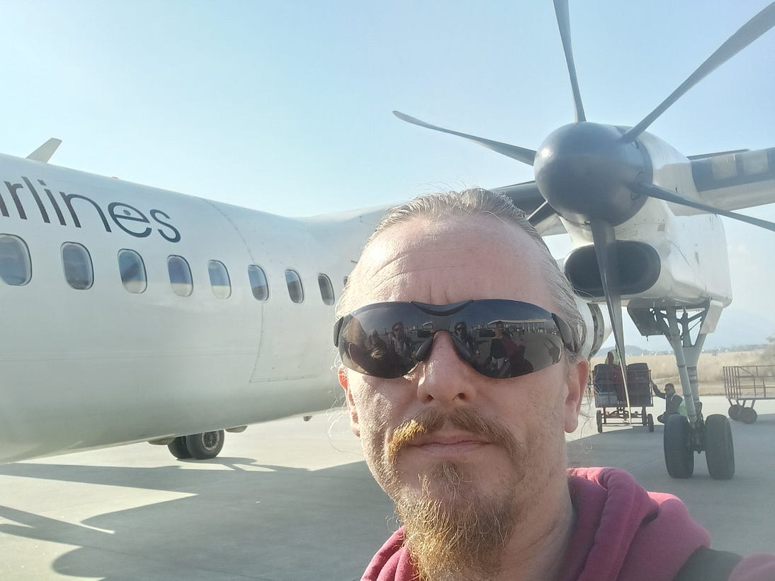 A selfie by your author standing in front of the wing and propellor of a Shree Airlines ATR-72 in Pokhara, Nepal.