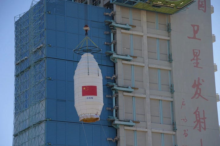 The Long March 4B first-stage heading to the launch pad and its fairing being placed atop of the launch vehicle on the launch pad.