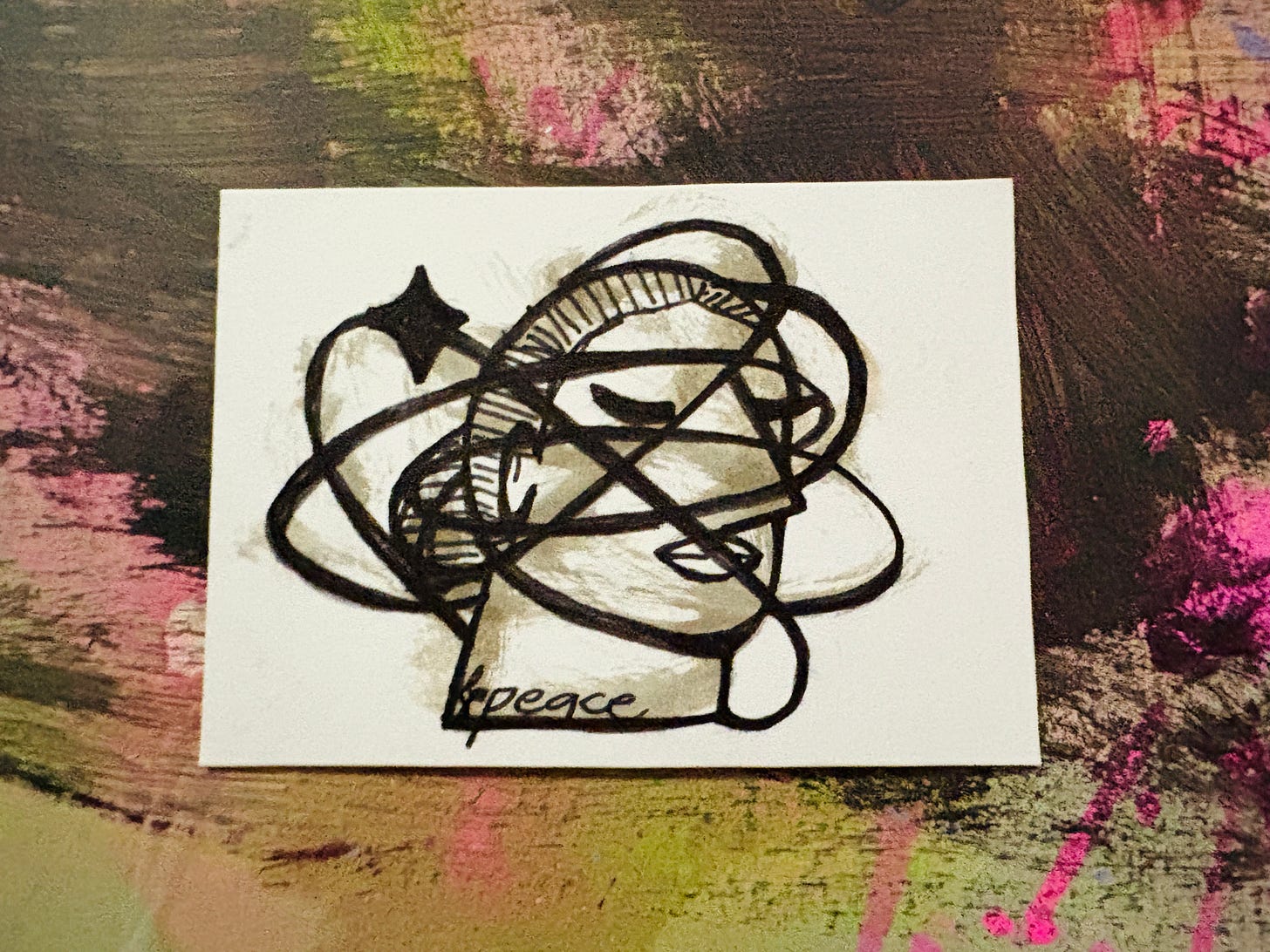 A black ink drawing of a person's head with their eyes closed and lines swirling around. There is a large sparkle on one of the lines and on their neck it says "peace"in cursive handwriting.