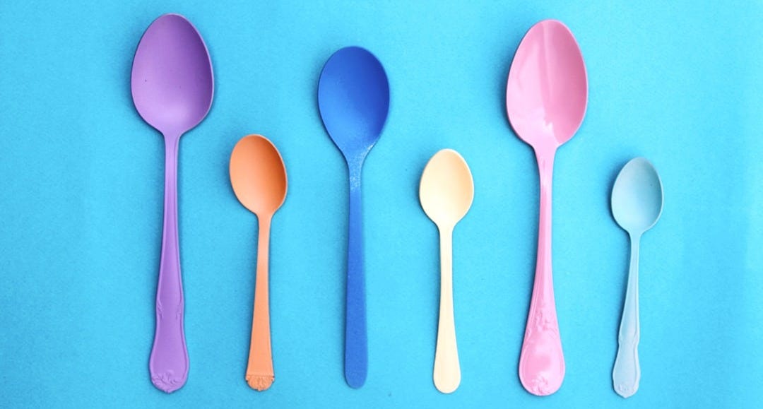 pink plastic spoon on pink and white polka dot textile pink plastic spoon on pink and white polka dot textile