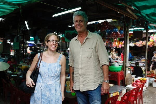 Laurie Woolever and Anthony Bourdain together, smiling in a food market in Vietnam