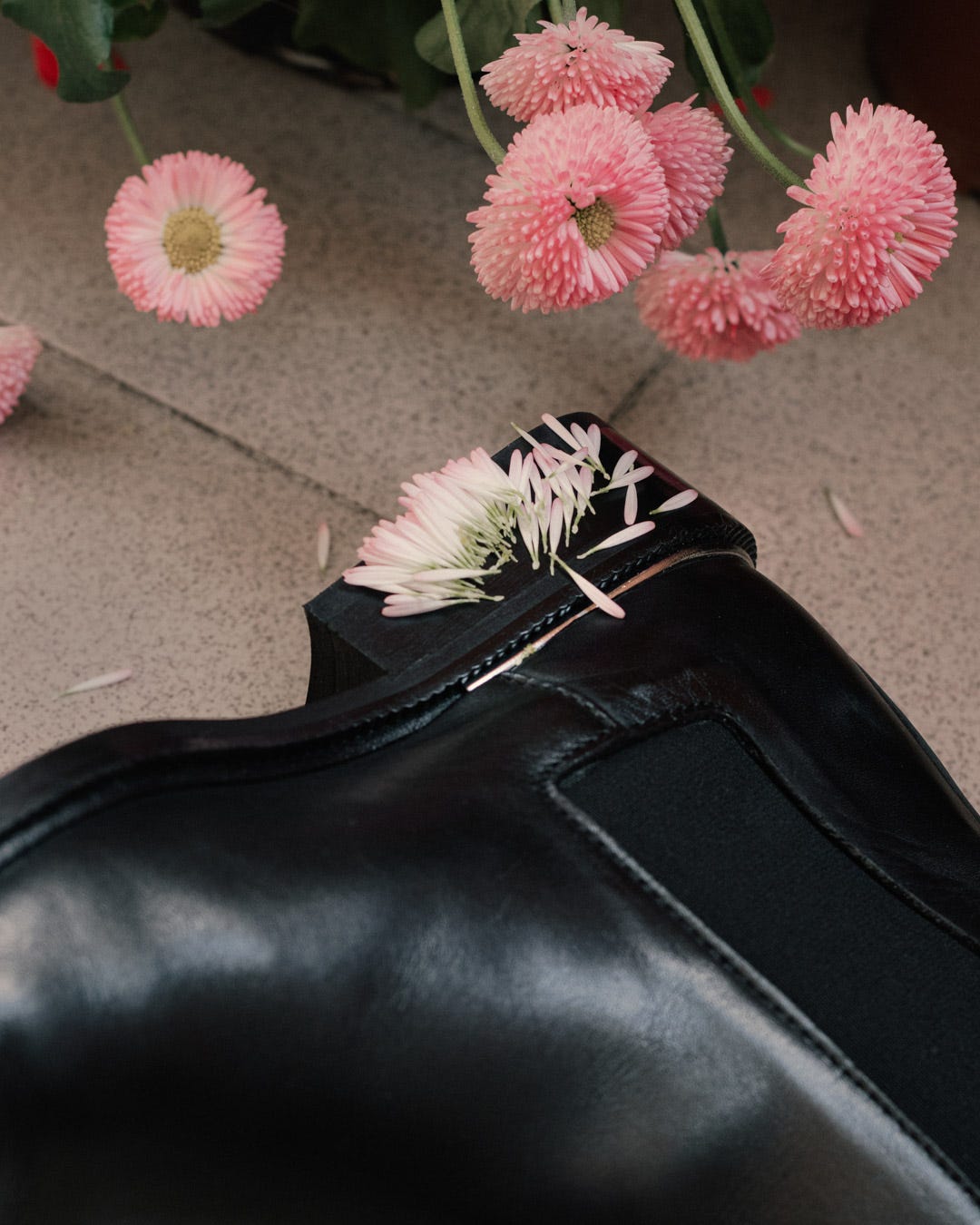 Pink petals fallen over boots