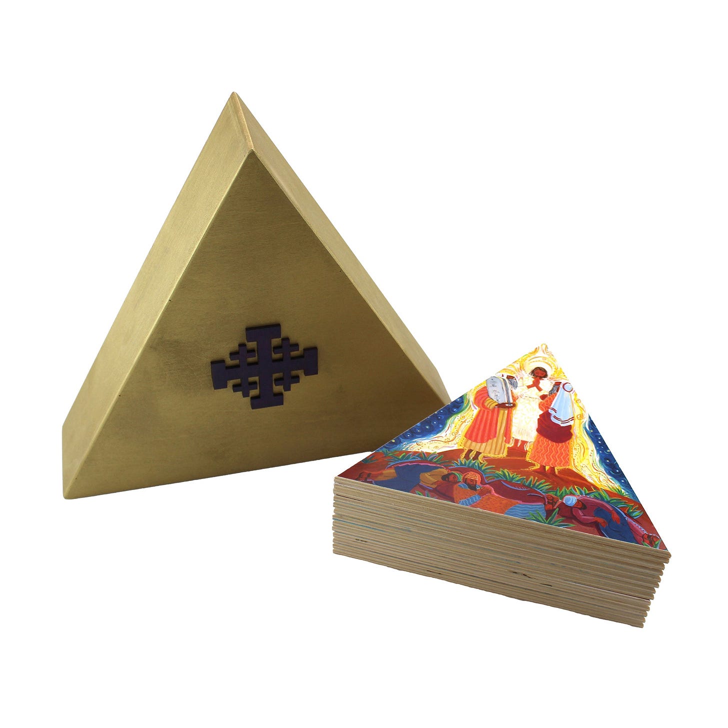 A triangular gold box stands upright. It has a purple Jerusalem cross on the front. Next to the box is a stack of triangular tiles. The top shows a colorful depiction of the Transfiguration.