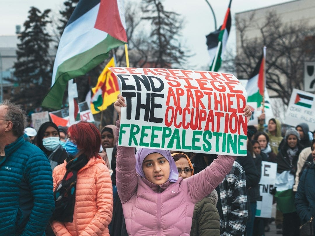 a woman holding a sign that reads free palestine