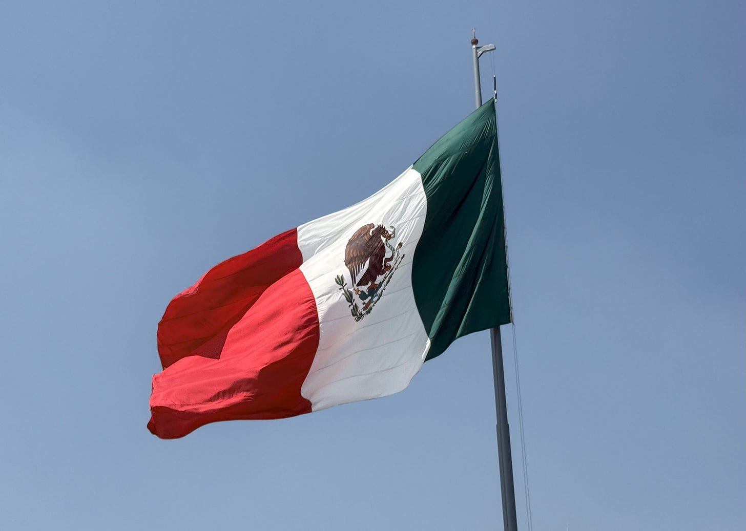 Mexican flag against a blue sky
