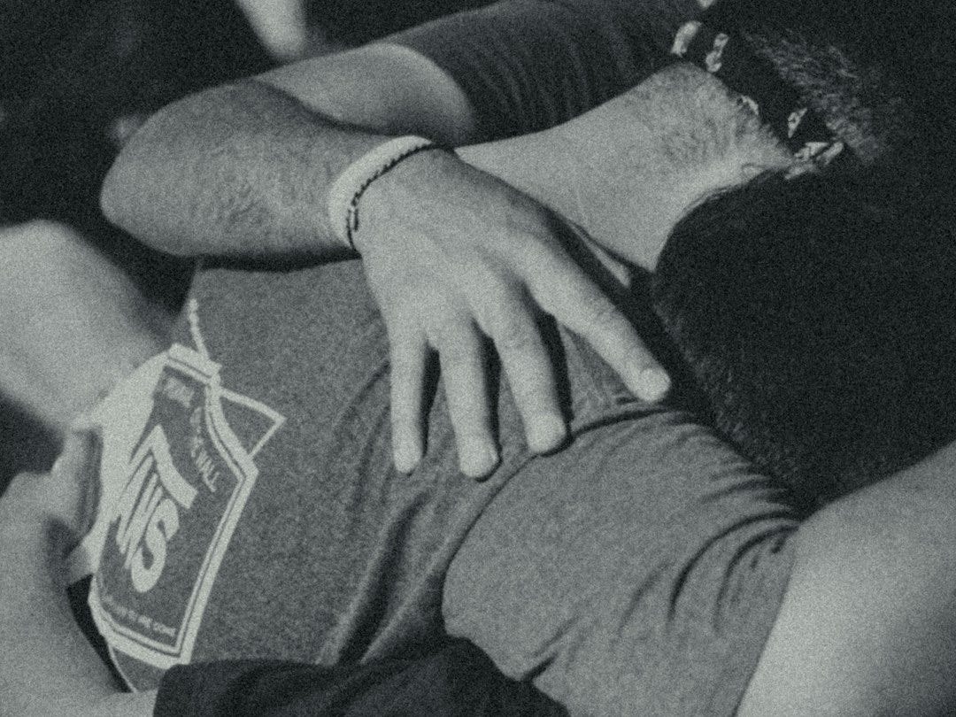grayscale photography of men doing group hug