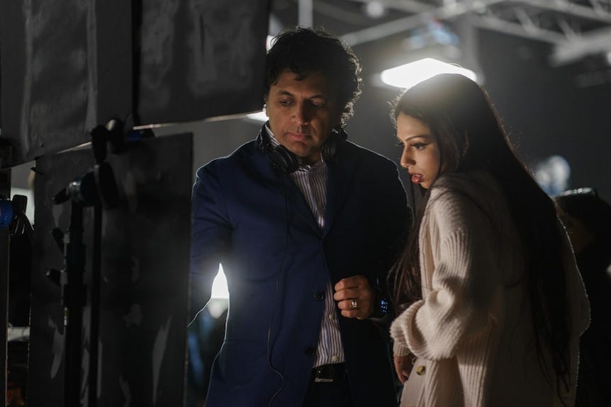 A man shows a woman something on a screen