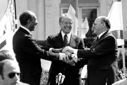 three men smile as they clasp hands three men smile as they clasp hands