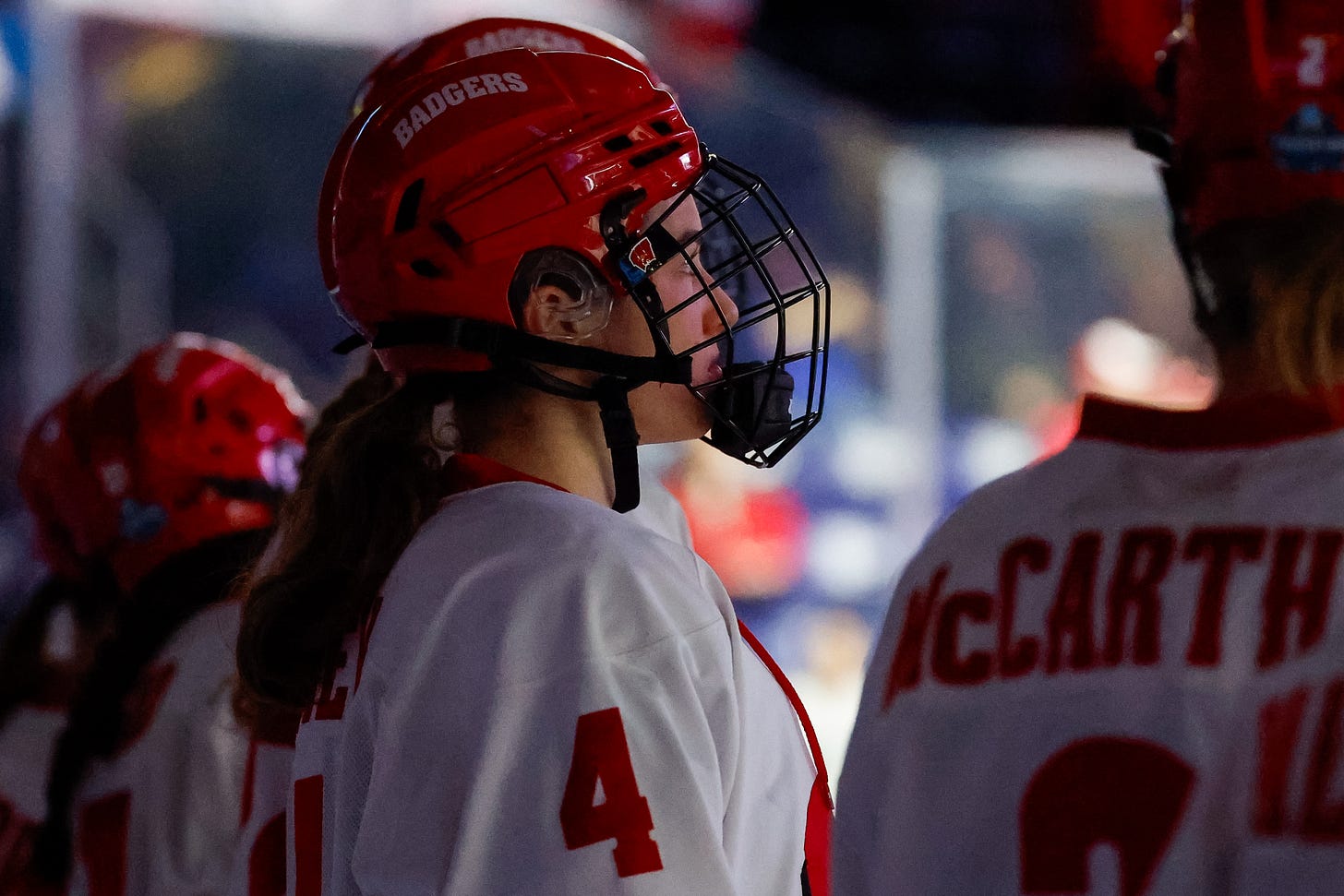 Caroline Harvey standing next to teammates on the ice Caroline Harvey standing next to teammates on the ice