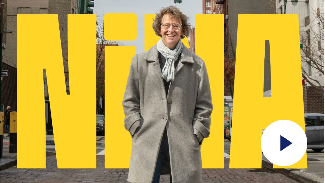 A campaign image for Nina’s intro video, shows Nina smiling in an overcoat with a bright yellow “NiNA” behind her. A campaign image for Nina’s intro video, shows Nina smiling in an overcoat with a bright yellow “NiNA” behind her.