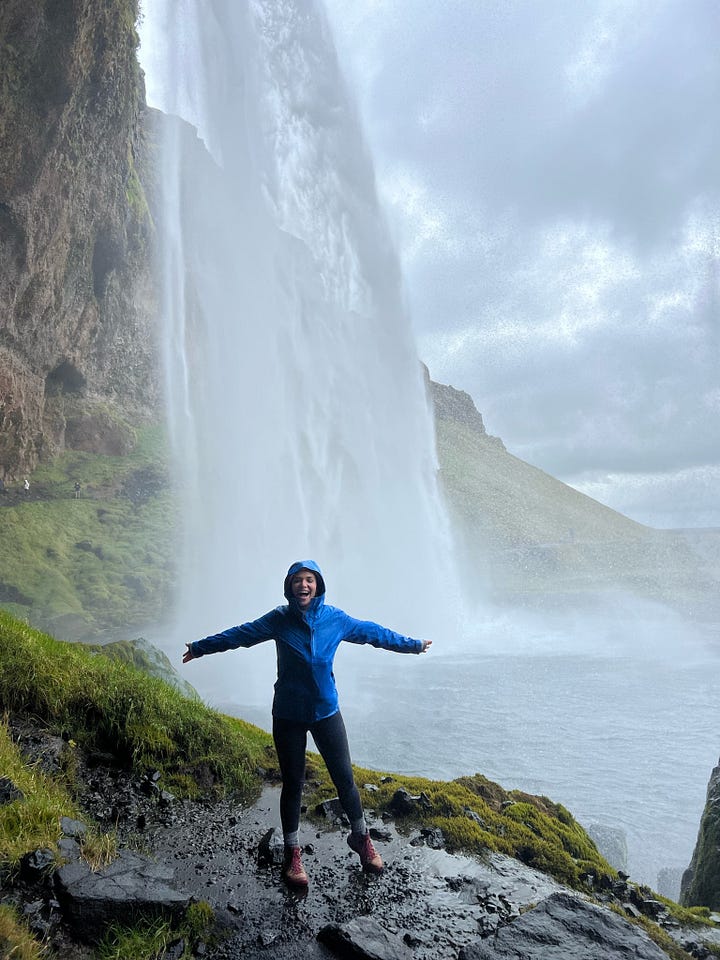 Counter-clockwise from top left: woman near base of the Seljalandsfoss waterfall as it pours into a small lake; selfie photo of woman near base of the Skogafoss waterfall, with a rainbow behind her and in front of the waterfall; selfie photo of woman from a view point with Fjadrargljufur canyon below and behind her; selfie photo of woman with strong winds blowing up from the Gullfoss waterfall behind and below her.