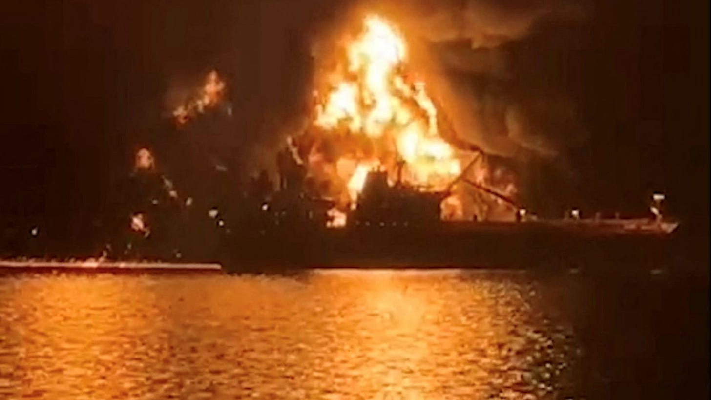 A ship is illuminated by fire from a burning vessel, after Iranian explosive-laden boats appear to have attacked two fuel tankers in Iraqi waters setting them ablaze, according to port, maritime security and risk firms, amid the U.S.-Israeli conflict with Iran, in this screengrab taken from a handout video released March 12, 2026.