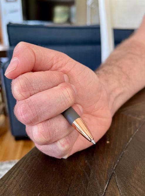 A hand holding a pen

Description automatically generated