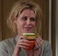 This may contain: a woman holding a bowl and looking at the camera This may contain: a woman holding a bowl and looking at the camera