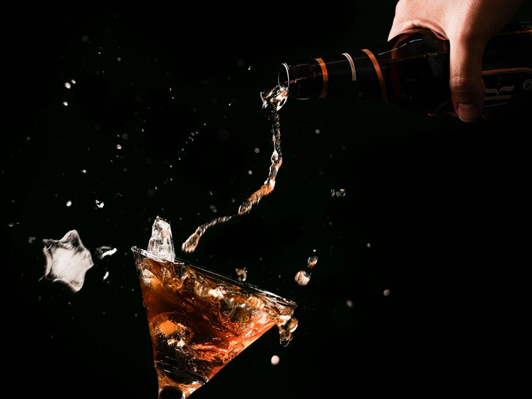 a person pouring liquid into a glass a person pouring liquid into a glass