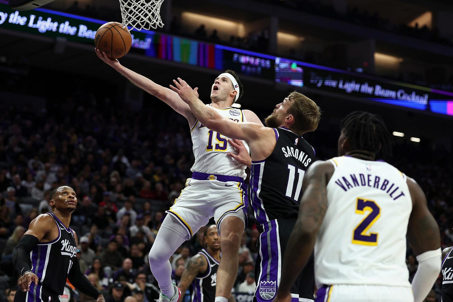 Lakers guard Austin Reaves draws a foul on Sacramento Kings center Domantas Sabonis as he puts up a shot.