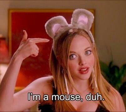 This may contain: a woman with bunny ears pointing to the side and saying i'm a mouse, duh