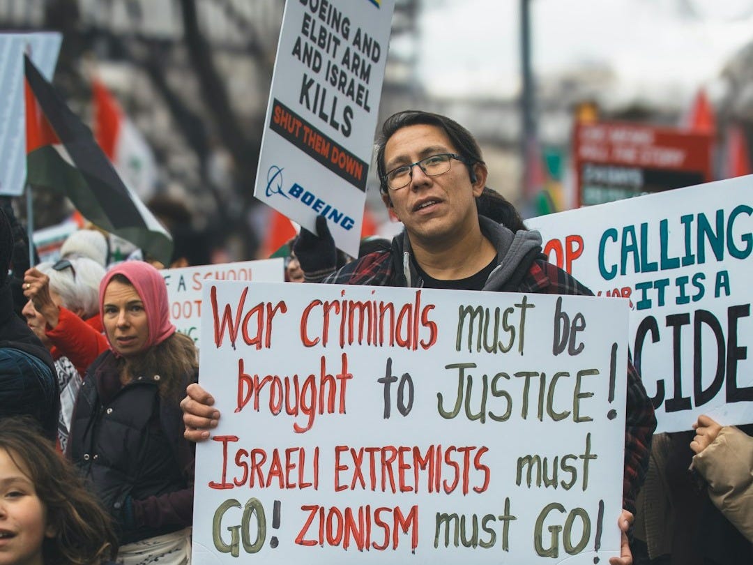 a man holding a sign in front of a crowd of people