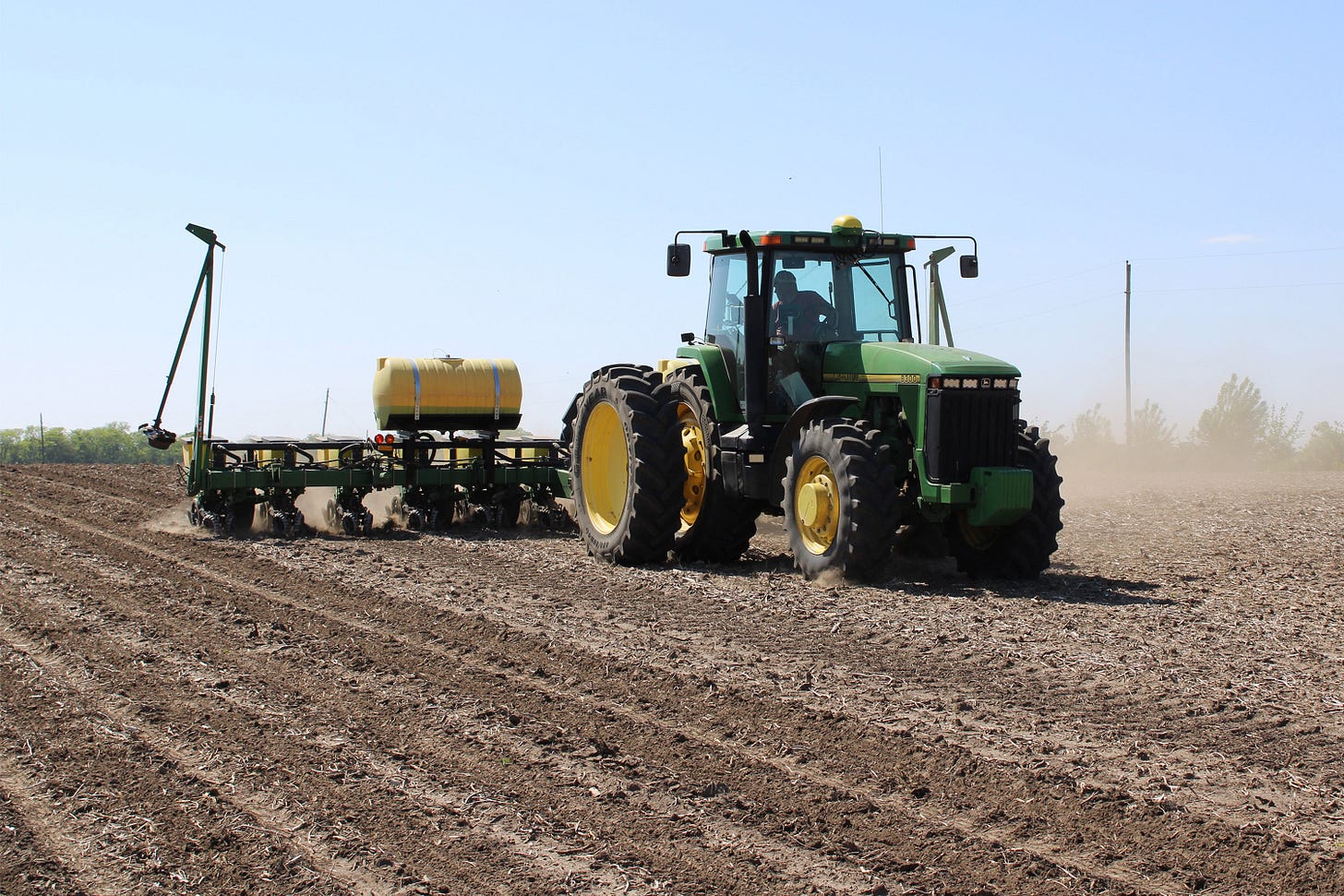 A photo of a tractor rolling across a field. A photo of a tractor rolling across a field.