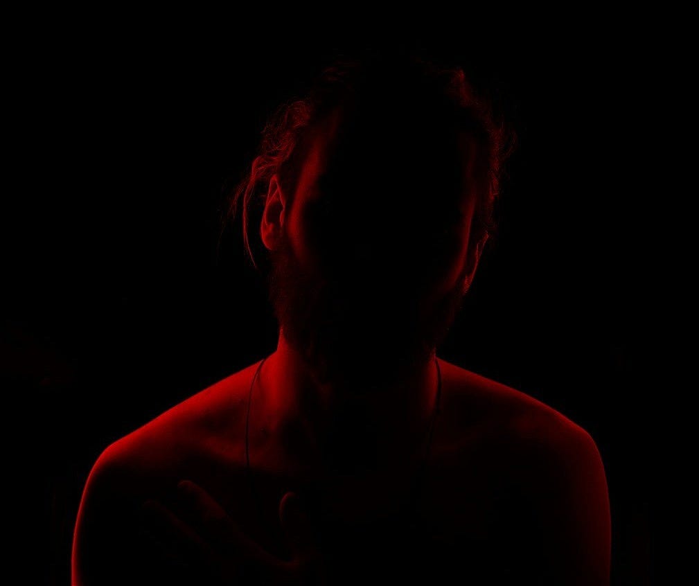 a woman in a dark room with a red light a woman in a dark room with a red light