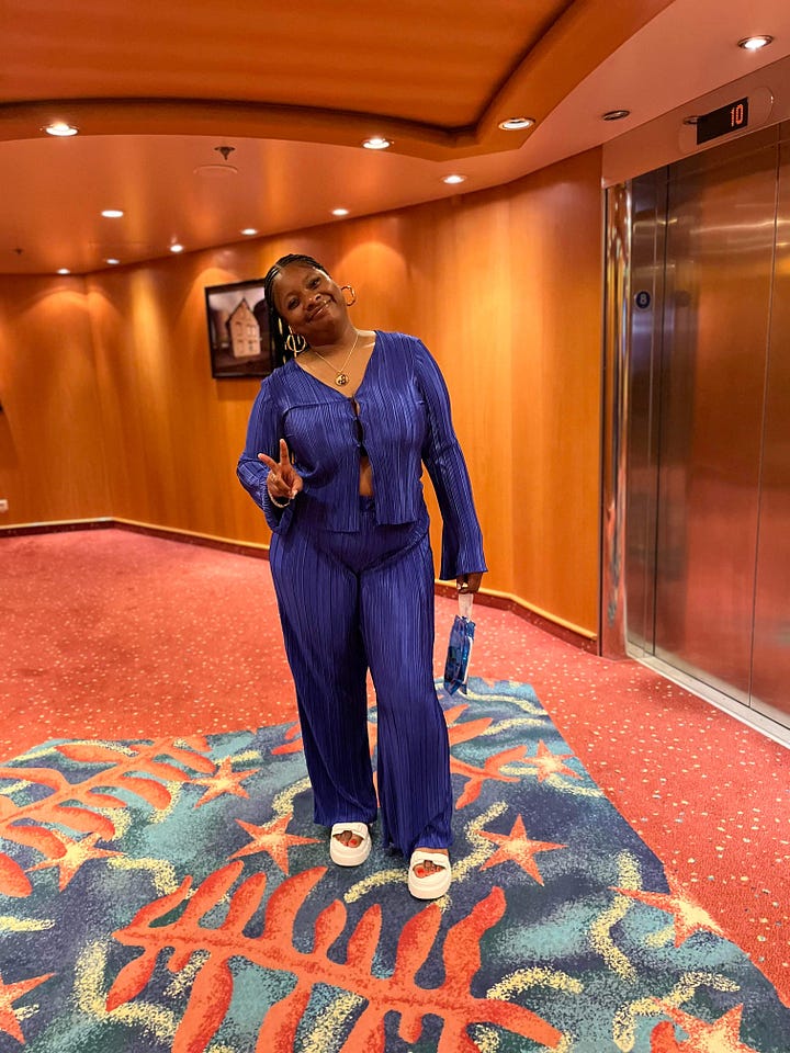 Left to right: Black women similing in the hallway near an elevator dressed in a blue silk outfit. Black women standing a hallway near an elevator on a cruise ship dressed in a brown matching outfit. Black woman admires the sea at night on a cruise ship dressed in a green sheet matching pants set. Black woman poses on a stair case in orange matching set.