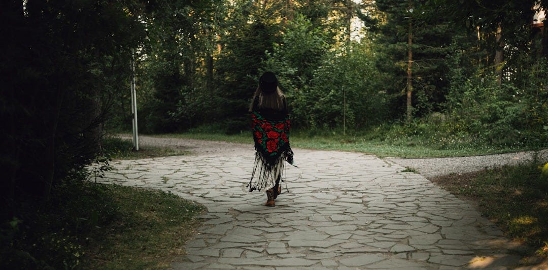 Woman walks away on a forest path. Woman walks away on a forest path.