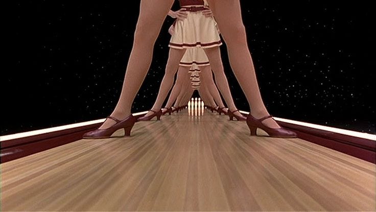 This may contain: a woman's legs with high heels standing on a bowling alley at night time