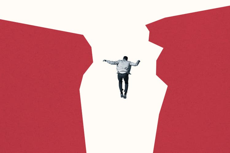 Rear view of man falling between red cliff