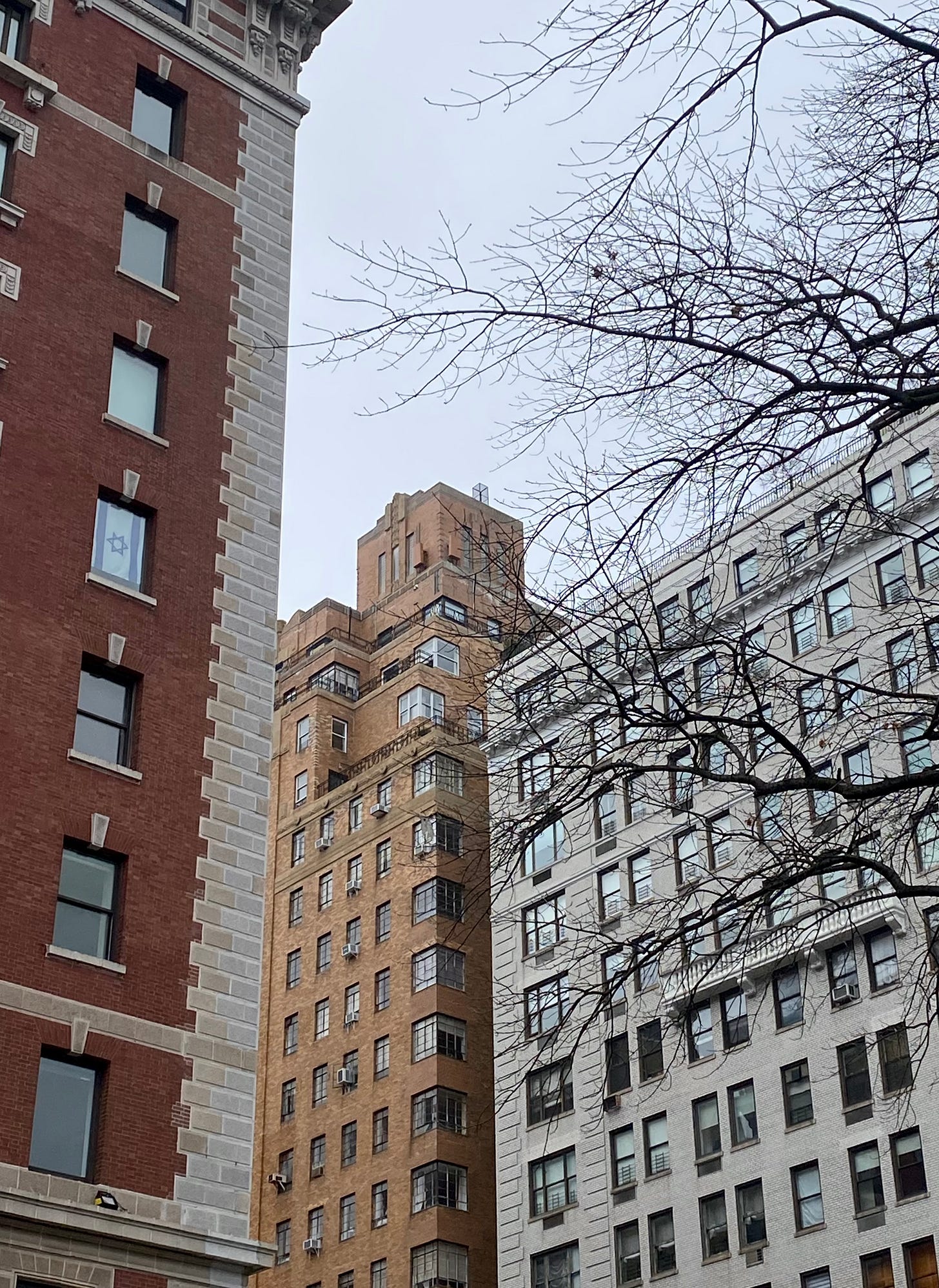 A light brown building with elegant setbacks, a square water tower structure and art deco architectural detailing.