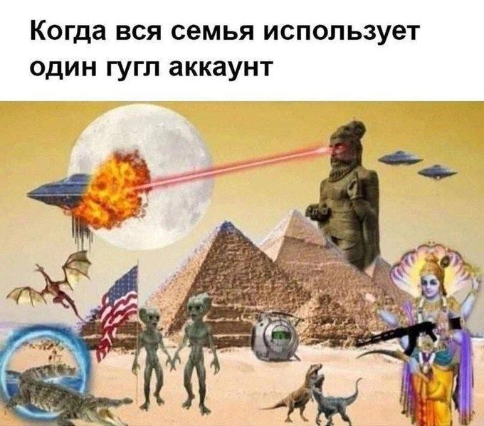Aliens with large heads stand on a desert landscape with pyramids. UFOs fly above, one emitting a laser beam. A statue resembling an ancient figure and a deity with multiple arms are present. Dinosaurs, a cat-crocodile hybrid, and an American flag are visible.