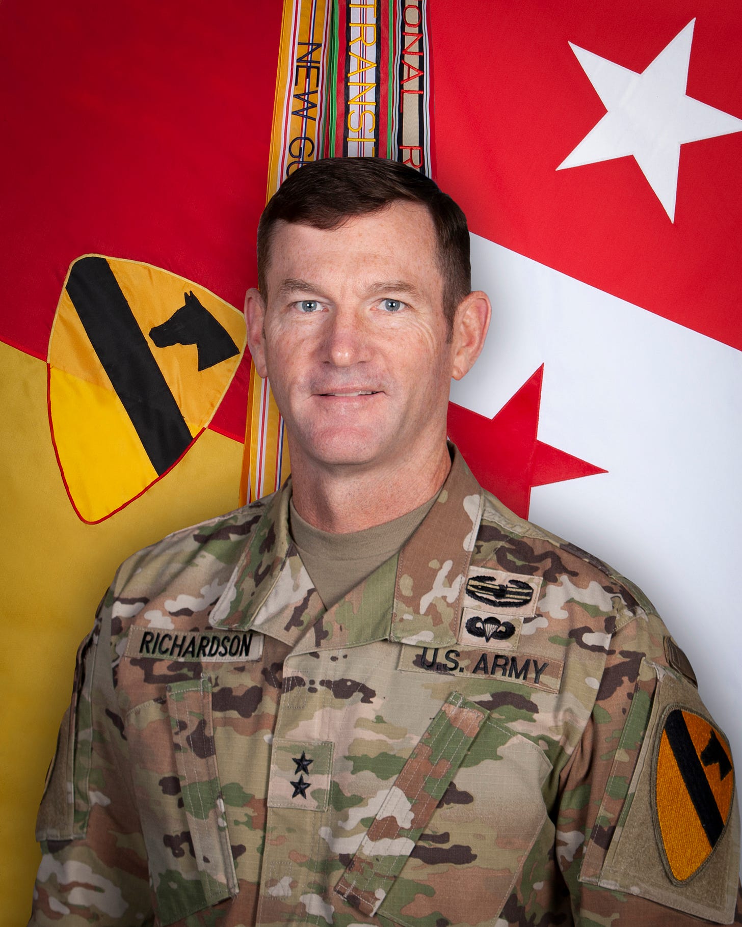Maj. Gen. John Richardson in Army camouflage uniform before unit and rank flags Maj. Gen. John Richardson in Army camouflage uniform before unit and rank flags