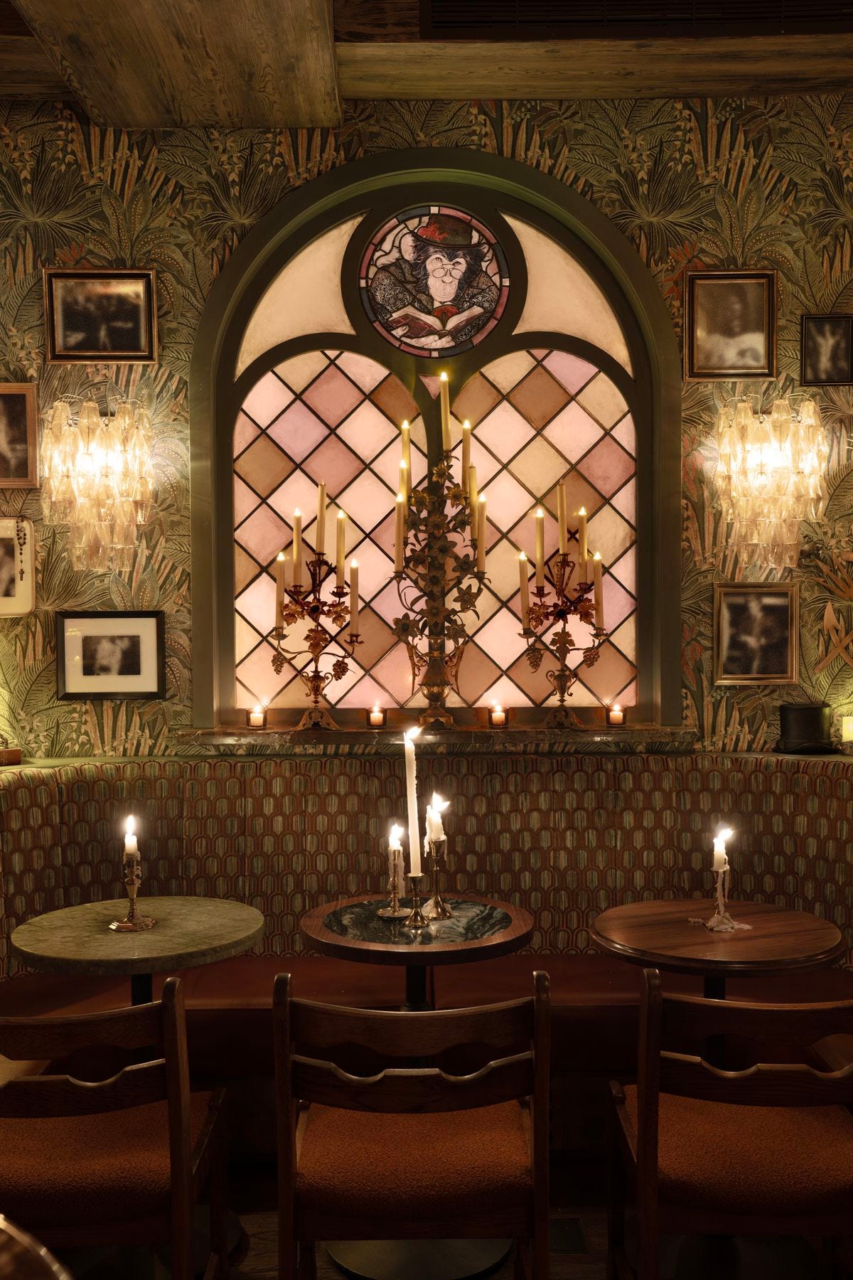 A restaurant with round tables and a stained glass wall.
