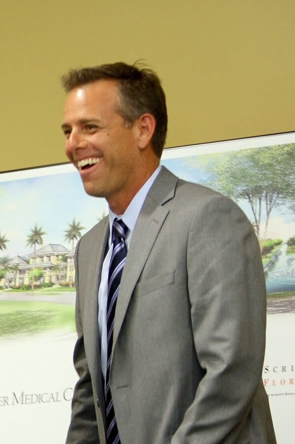 Paul Walczak in a gray suit and blue striped tie.