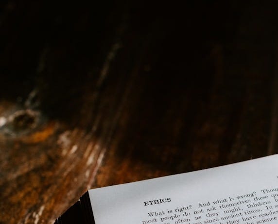 an open book sitting on top of a wooden table an open book sitting on top of a wooden table