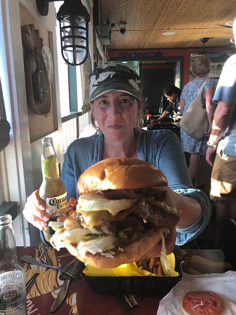 A collection of photos from Hawaii, including two whale tails rising from the water, a painted Maui mailbox, an historic museum in Lahaina, turtles on the beach, and the author enjoying a large burger in a location that's now likely burned.