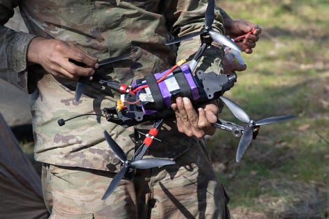 U.S. Army soldiers training with Titan V3 counter-unmanned aerial system technology in a wooded Latvian environment during the multinational Saber Strike 26 exercise.
