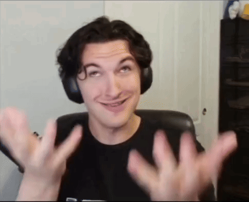 a man wearing headphones is smiling and making a funny face while sitting in a chair .