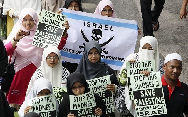 Protesters hold placards condemning Israel's raid on a pro-Palestinian flotilla trying to break the Israeli security blockade of Gaza, June 4, 2010. Under a heavy police presence, more than 5,000 protesters, led by opposition leader Anwar Ibrahim, waved Palestinian flags and shouted "Long live Islam," "Free Gaza" and "Done with Israel." (photo credit: AP Photo/Mark Baker)