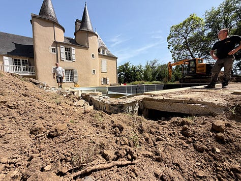 An excavator beside the château digs out the old swimming pool, with piles of earth in the foreground. The old pool half drained, its liner peeling away and green algae water pooled in the deep end. The cleared site where the old pool was, now bare earth and mounds of soil, with an excavator at the far end.