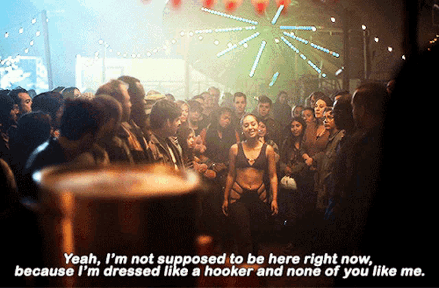 a woman in a bikini is standing in front of a crowd and says yeah i 'm not supposed