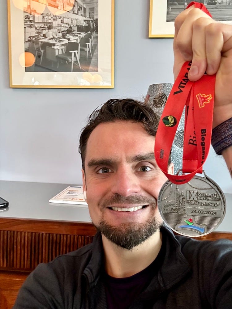 Na zdjęciu trzymam medal z biegu na 5 km, w który udało mi się poprawić życiówkę.