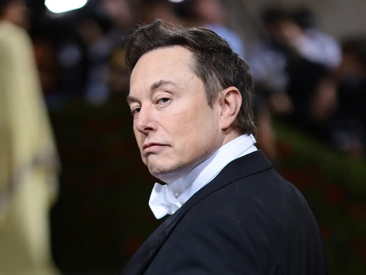 Elon Musk looking serious at a public event, often cited as an example of extreme work expectations.