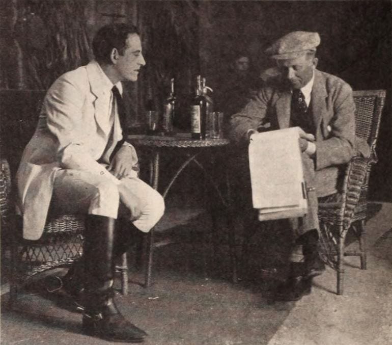 An image of two men reading a script in 1920