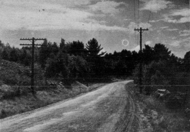 A total solar eclipse over a country road