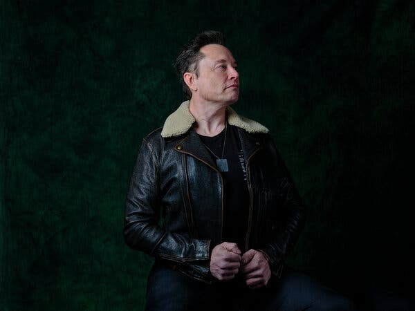 Elon Musk wears a dark leather jacket with a fur collar against a dark background. Elon Musk wears a dark leather jacket with a fur collar against a dark background.