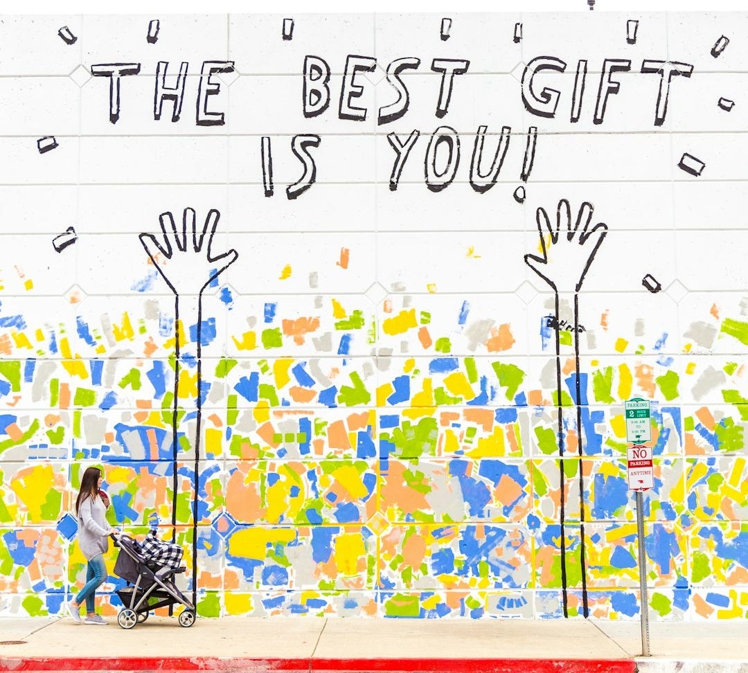 woman walking beside wall with the best gift is you graffiti woman walking beside wall with the best gift is you graffiti