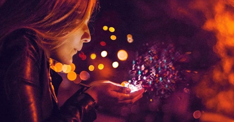 woman blowing sprinkle in her hand