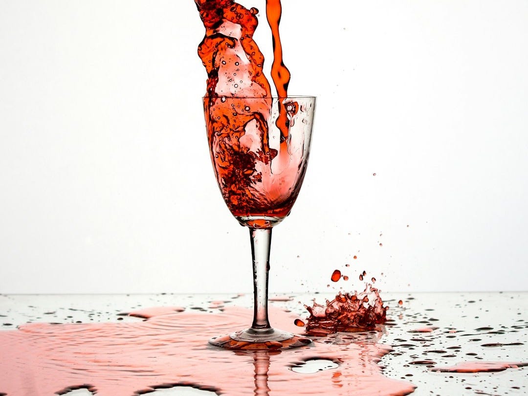 red liquid poured on wine glass red liquid poured on wine glass